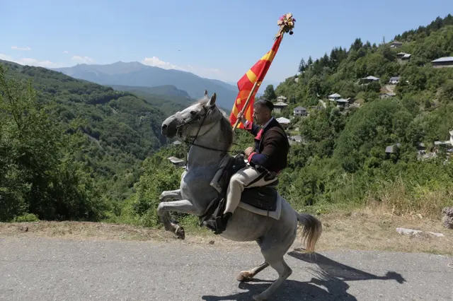Svadbenu kolonu u povratku prema centru sela predvodi barjaktar koji u više navrata tera konja da se propinje na zadnje noge.