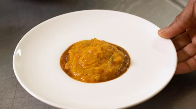 Bouillie orange/jaune servie dans une assiette creuse