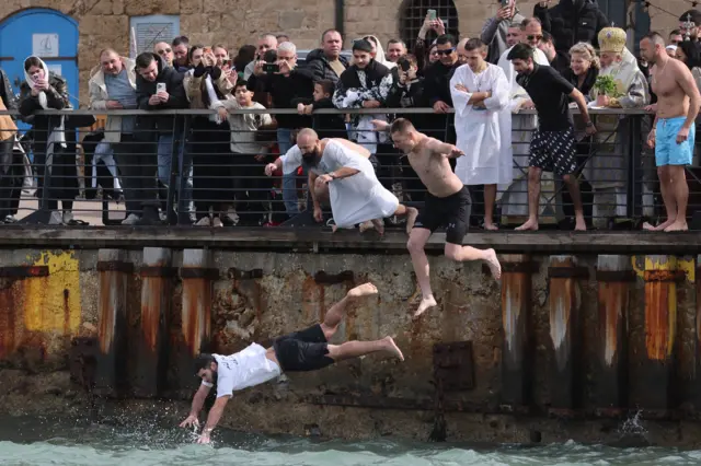 Хришц́ански верници из грчке православне цркве Архангела Михаила скачу у воду како би извукли крст из Средоземног мора током прославе Богојављања у Старој луци Јафа у Тел Авиву, Израел, 19. јануара 2026.