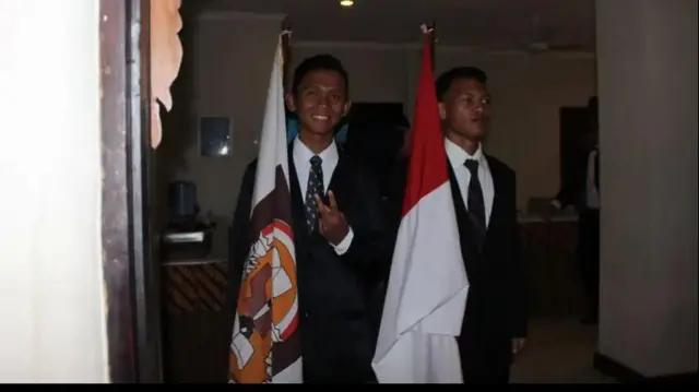 Jaka (kanan) membawa bendera merah putih dalam proses wisuda SMK-nya 