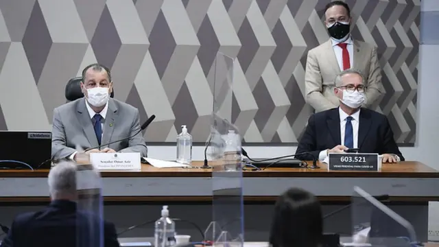 Senadores Omar Aziz e Renan Calheiros sentados lado a lado na mesa diretora da CPI da covid-19