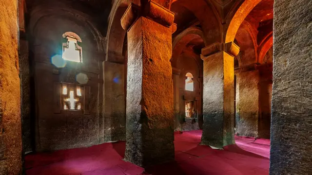 Свет проникает в храм через прорези в каменной стене в виде крестов