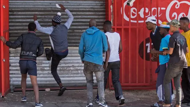 Des pillards qui essaient d'entrer par effraction dans un magasin