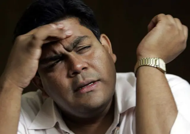 এক ব্যক্তি চোখ কুচকে কপালের চামড়া ধরে আছেন।