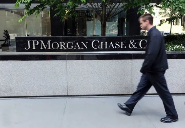 Homem passandobetano app originalfrente ao prédio da JPMorgan Chase