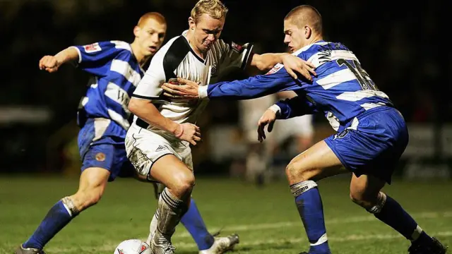 Lee Trundle afise umupira mu kibuga, ari hamwe n'abandi bakinyi babiri