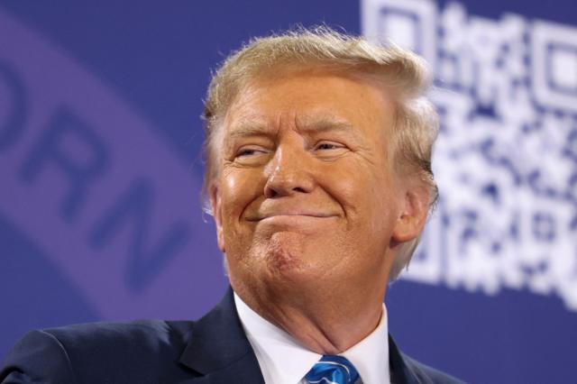 Donald Trump sorrindo e olhando para o lado