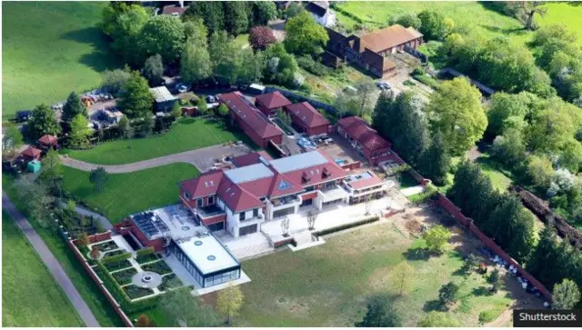 Сүрөттө: Кулибаев Эндрюдан сатып алган үйдү бузуп, анын ордуна 14 уктоочу бөлмөсү бар жаңы үйдү курган, бирок ага эч ким көчүп кире элек