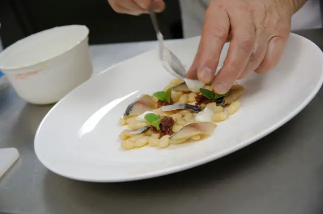 Préparation de maquereau fumé avec des haricots de Sorana et de l'oignon de Tropea. 