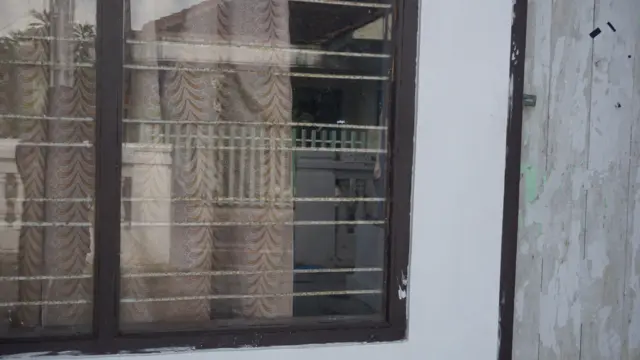 Jendela di samping pintu tempat tinggal Siti dan Daniel yang kini sudah kosong.