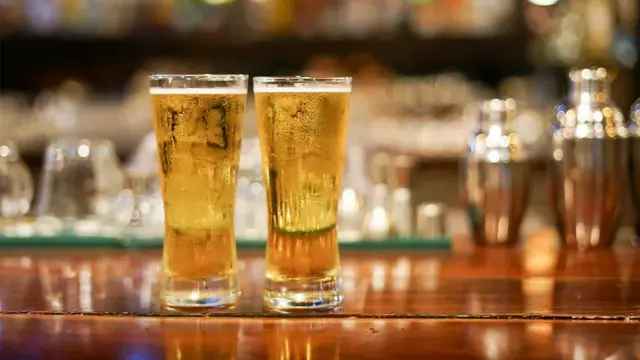 Deux verres de bière posées sur une table