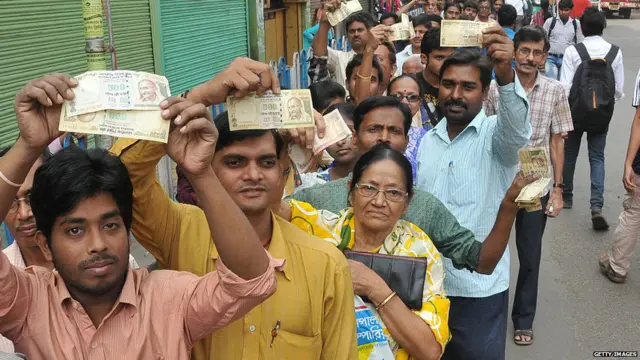 ndian Showing 1000 and 500 rupee and long time waiting a long line Many Deposit and change old to new currency at Front of STATE BANK OF INDIA