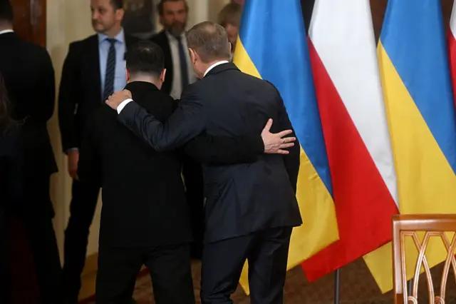 Зеленский и Туск обнимают друг друга за плечи.
