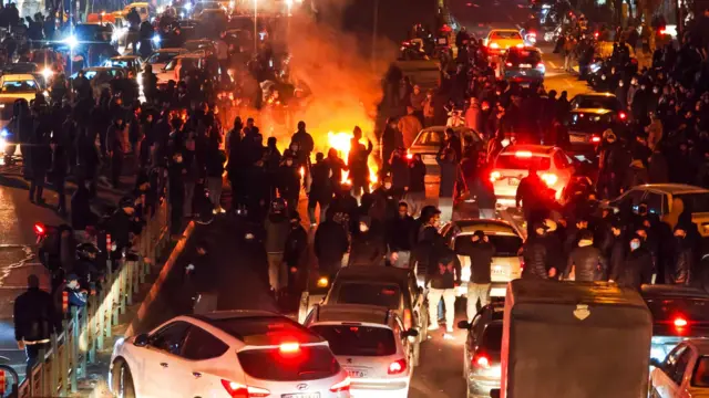 İranlılar, 9 Ocak 2026'da Tahran'da düzenlenen bir protesto gösterisi sırasında bir sokağı trafiğe kapatarak toplandı.