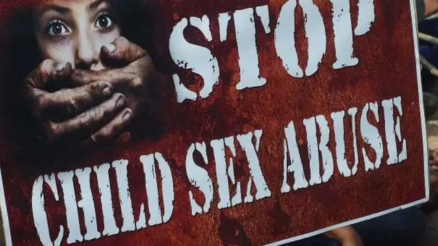 Spanduk bertuliskan 'stop kekerasan seksual pada anak'.