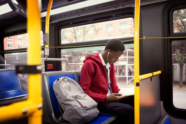 Homem lendo livro no ônibus