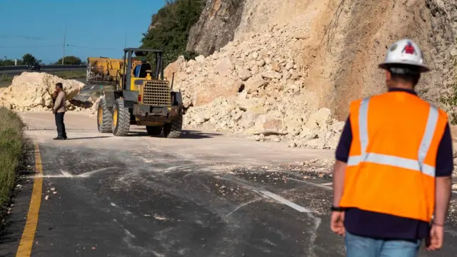 Un tractor despejando un derrumbe en una carretera en Puerto Rico.