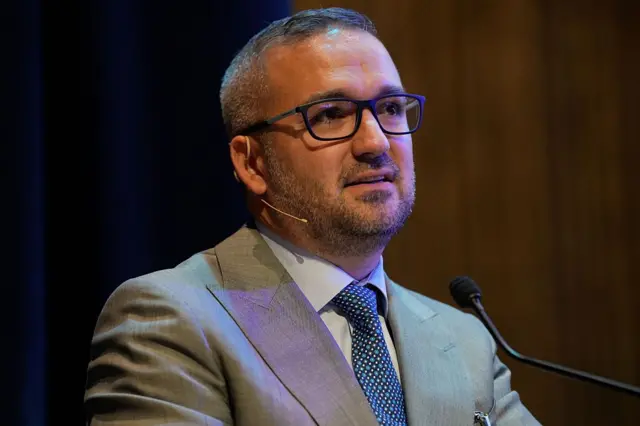 Fatih Karahan üzerinde bir takım elbiseyle mikrofona konuşurken