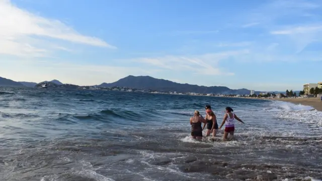 Turistas jugando en las olas.