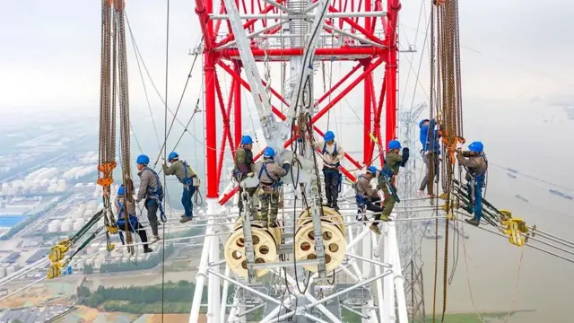 Công nhân xây dựng đường dây điện siêu cao thế (UHV) dọc theo sông Trường Giang của Trung Quốc