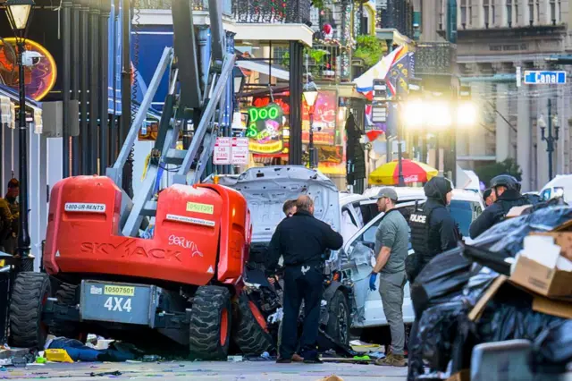 Investigadores rodean una camioneta blanca estrellada contra una grúa