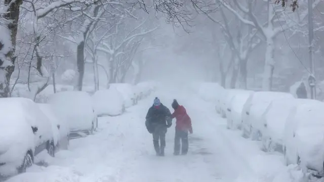 Люди идут по улицам Нью-Йорка во время февральской метели