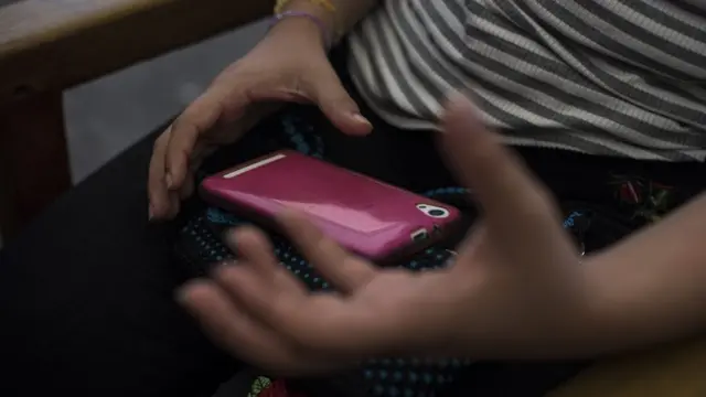 Las manos de Hebe con su celular.