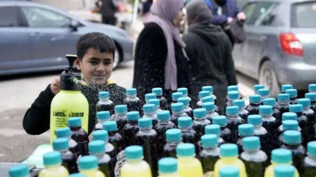 طفل يقف بجانب "بسطة" لبيع العصير.