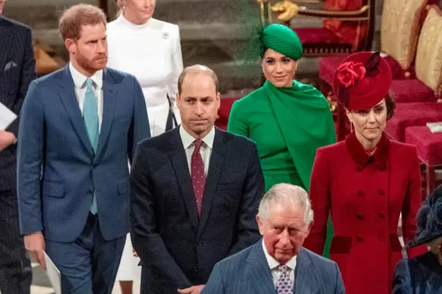 Fotografia colorida mostra dois casaissuporte fezbetroupas formais, Harry e Meghan e William e Kate, caminhando atrássuporte fezbetCharles, que usa um terno