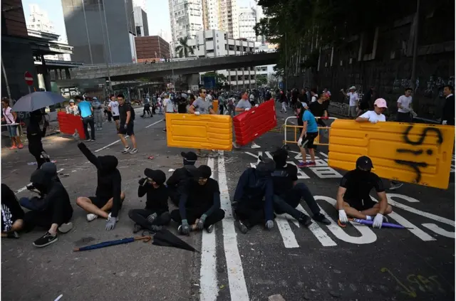 11月16日，有香港市民在街头清除抗议人士摆放的障碍物。