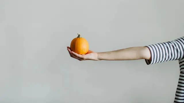 一位女性的手举着一个水果