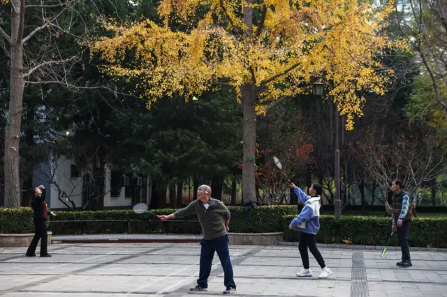 Pessoas praticam esportes em praça na China