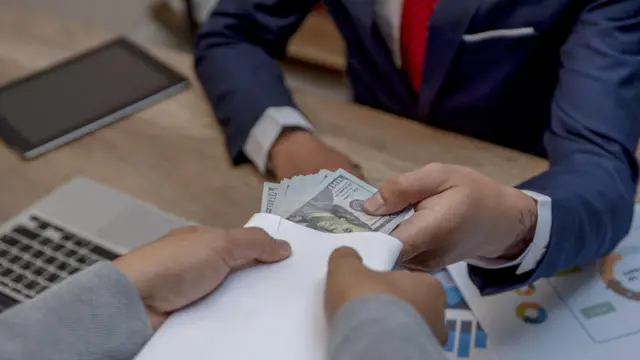 Homme acceptant un "pot de vin". 