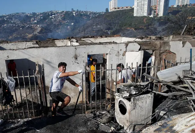 Personas trabajando tras el paso del incendio en Viña del Mar.
