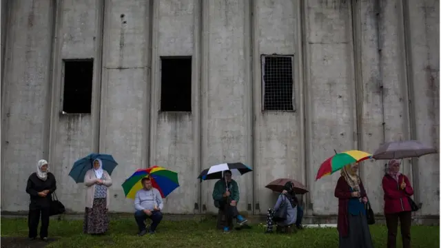 Grupa ljudi čeka dolazak tabuta