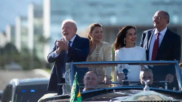 O presidente eleito do Brasil Luiz Inácio Lula da Silva gesticula para apoiadores junto comesposa Rosangela da Silva, o vice-presidente eleito Geraldo Alckmin eesposa Maria Lucia Ribeiro Alckmin enquanto se dirigem ao Congresso Nacional para o cerimôniaposse presidencial01janeiro2023Brasília, Brasil