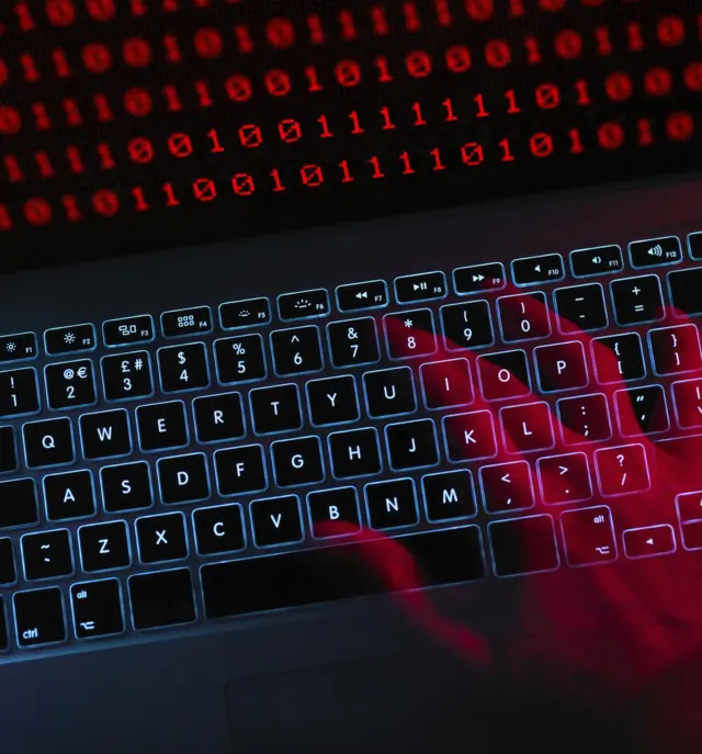 Mano, teclas y código binario en primer plano