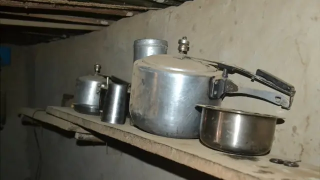 फळीवर ठेवलेली भांडी आणि त्यावर साचलेली धुळ