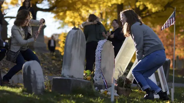Mujeres tomándose fotos frente a la tumba de Anthony.