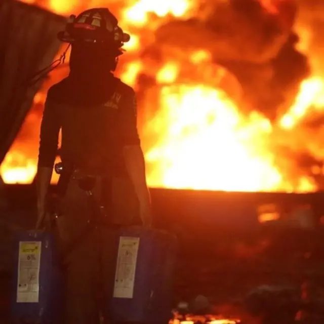 ณัฐภัทรกำลังขนถังน้ำยาฉีดโฟมเข้าไปที่เกิดเหตุ