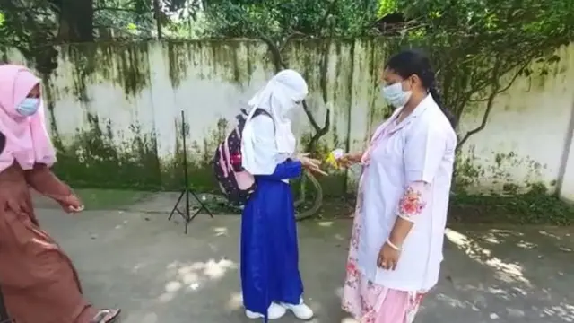 স্কুলে প্রবেশের আগে শিক্ষার্থীদের হাতে জীবাণুনাশক দেয়া হচ্ছে