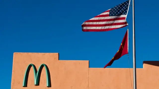 El logotipo de la compañía junto a una bandera de EE.UU.