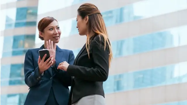 Duas mulheres chinesas conversam na rua