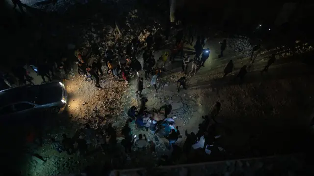 فلسطينيون قرب المدرسة التي تعرضت لقصف إسرائيلي في خان يونس، الصورة أخذت من مكان مرتفع