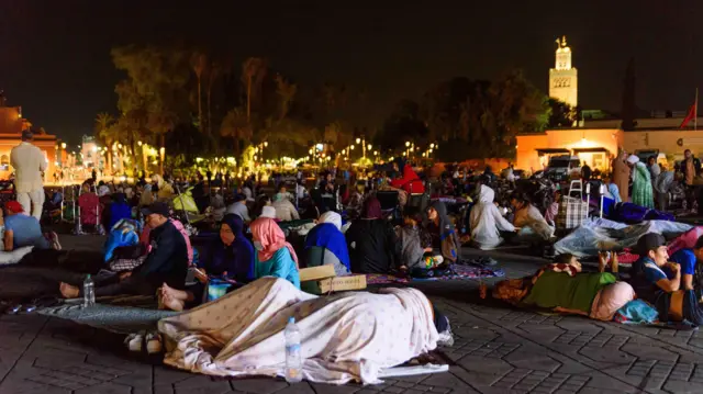 Pipo sleep ontop di pavement of Jemaa el Fna square for night on 10 September wit Kutubiyya Mosque mosque tower for di background