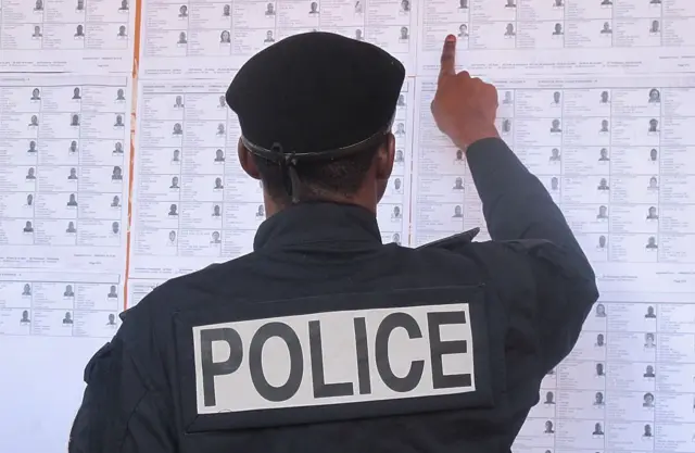 Un policier devant un babillard