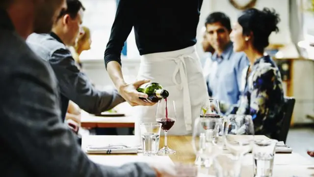 Garçom servindo vinho em restaurante