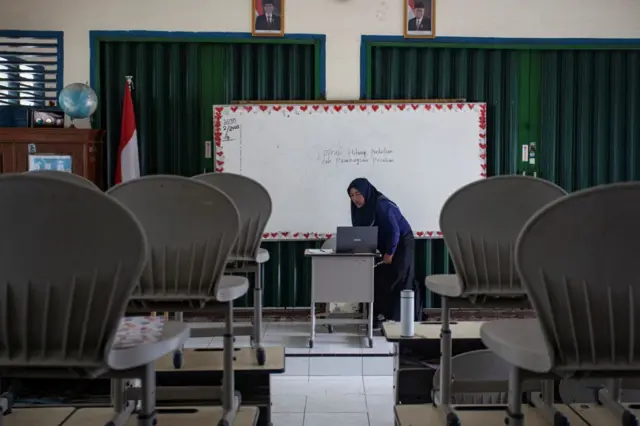 Guru sekolah dasar Eli Triana, 43, mengajar murid-muridnya secara online karena kualitas udara yang memburuk yang disebabkan oleh kebakaran hutan di Sumatera Selatan setelah pemerintah daerah memerintahkan sekolah untuk beralih online di Palembang pada 5 Oktober 2023.