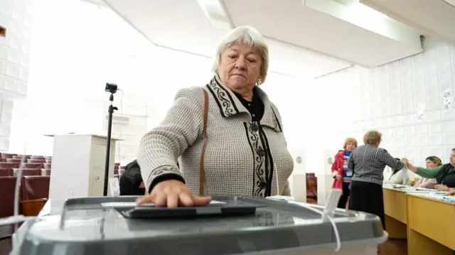 Избирательница голосует на участке