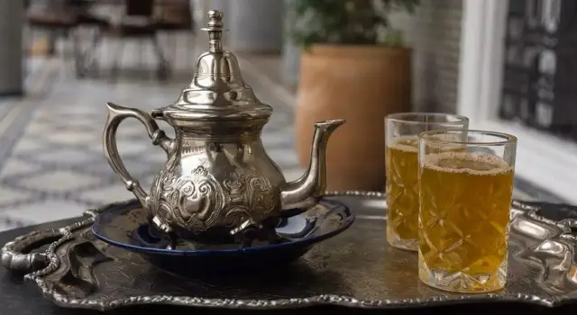 Une théière artisanale et deux verres de thé 